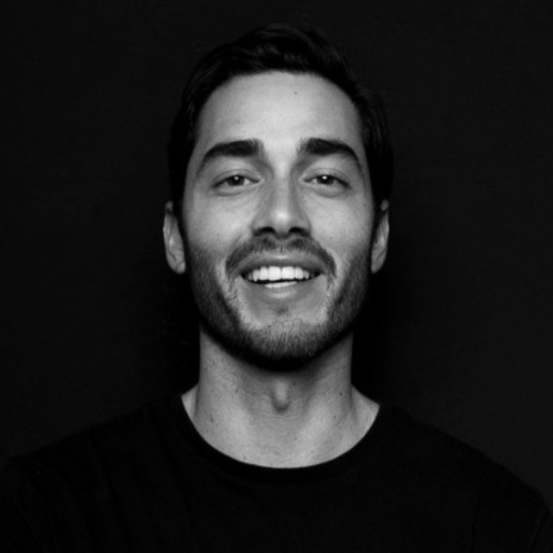 Portrait of a woman with brown hair on a flat gray background.